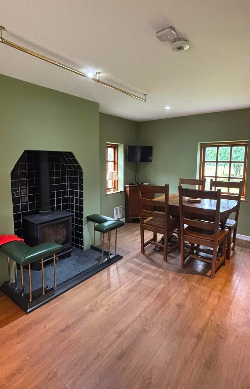 The sitting and dining room in the Bothy at Glen Dessary with a wood-burning stove