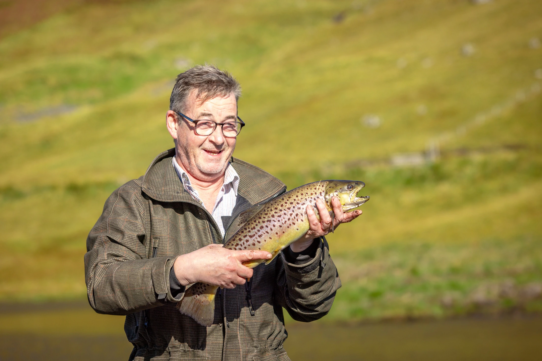 A guest with a large brown trout taken from the Lodge loch at Glen Dessary